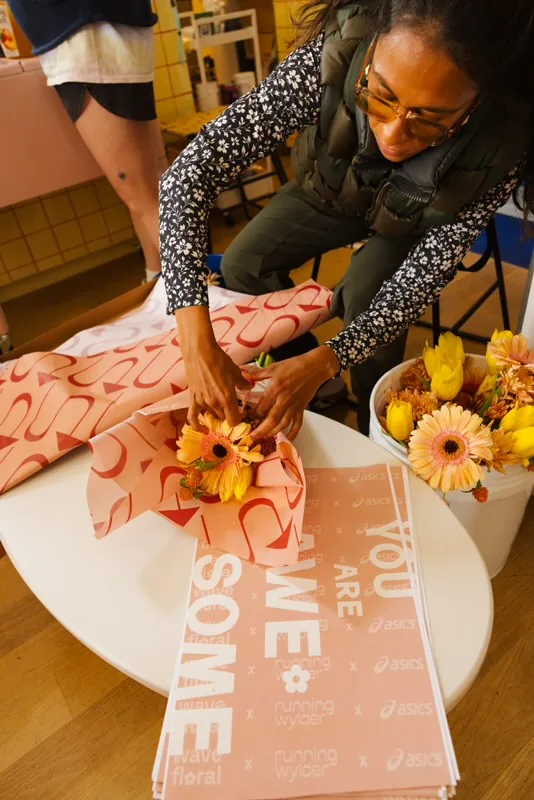 Bouquets wrapped in co-branded Asics x Running Wylder x Wave Floral paper at the San Francisco Marathon activation