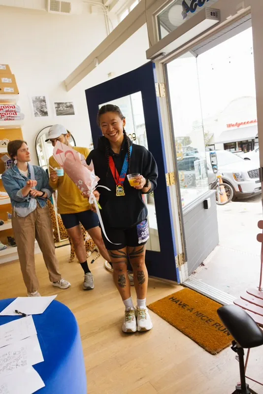 A marathon finisher with her medal and Wave Floral bouquet at the Asics activation