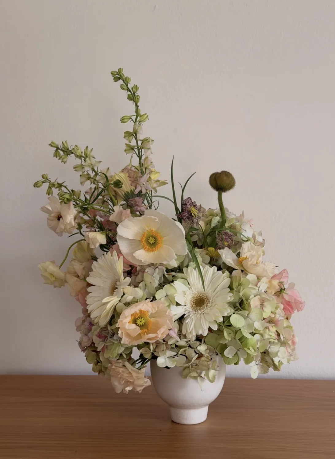 Soft cream and green arrangement with Icelandic poppy, gerbera and antique hydrangea