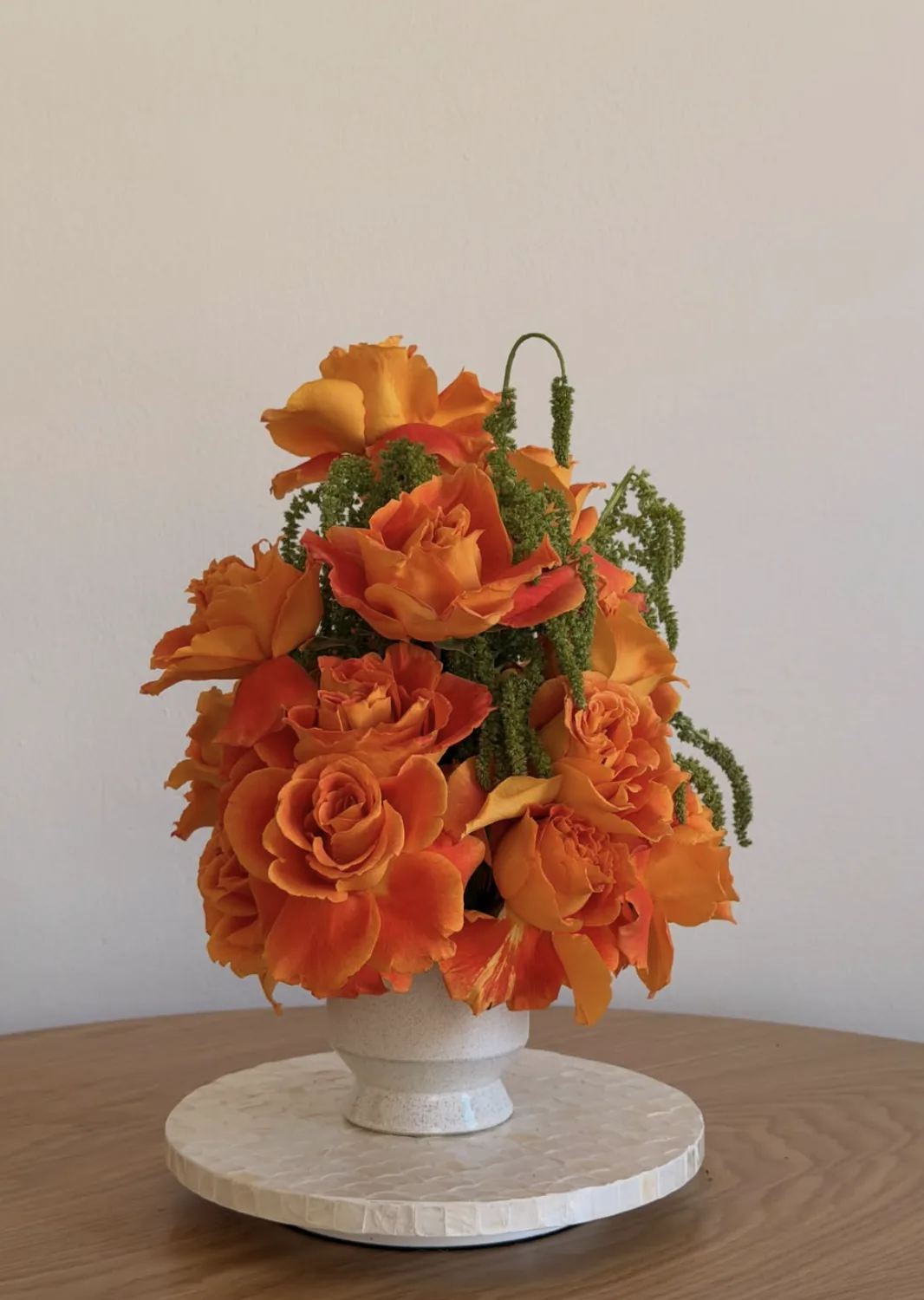 Monochrome orange arrangement of garden roses with green hanging amaranthus