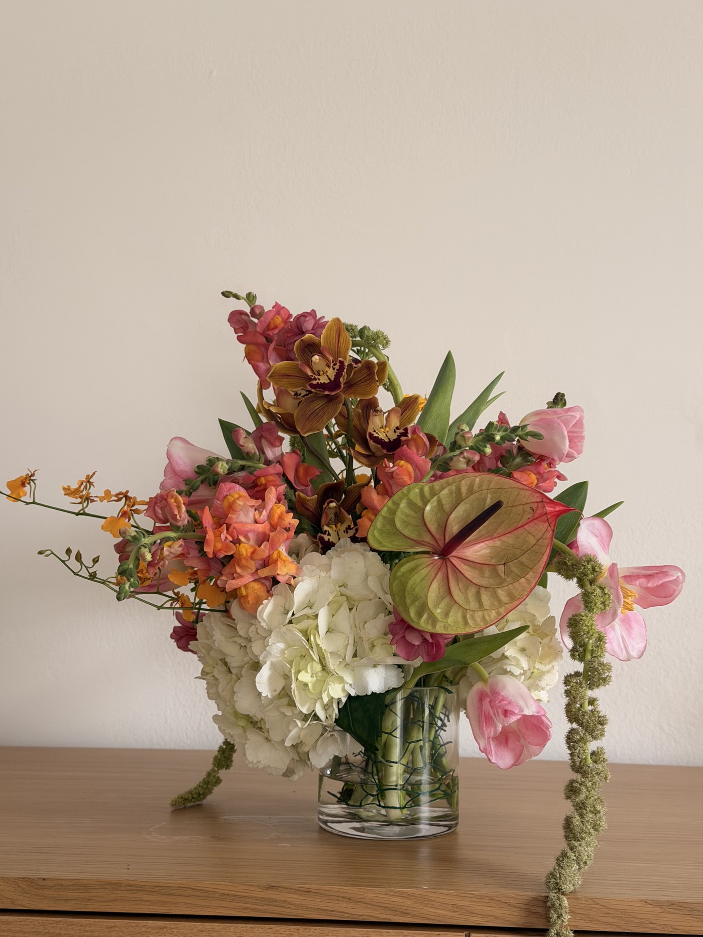 Medium arrangement with cymbidium orchid, anthurium, snapdragon and white hydrangea
